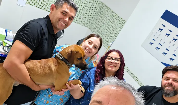 Equipe do Aricanduva Centro Veterinário com um cão e seus tutores